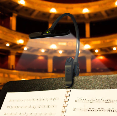 The BrightFlex light clipped on a music stand with sheet music.