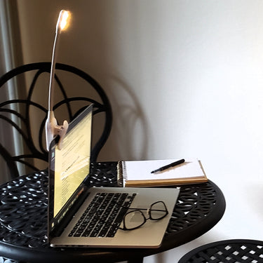 The WonderFlex light in white clipped on a laptop to shine on the keyboard.